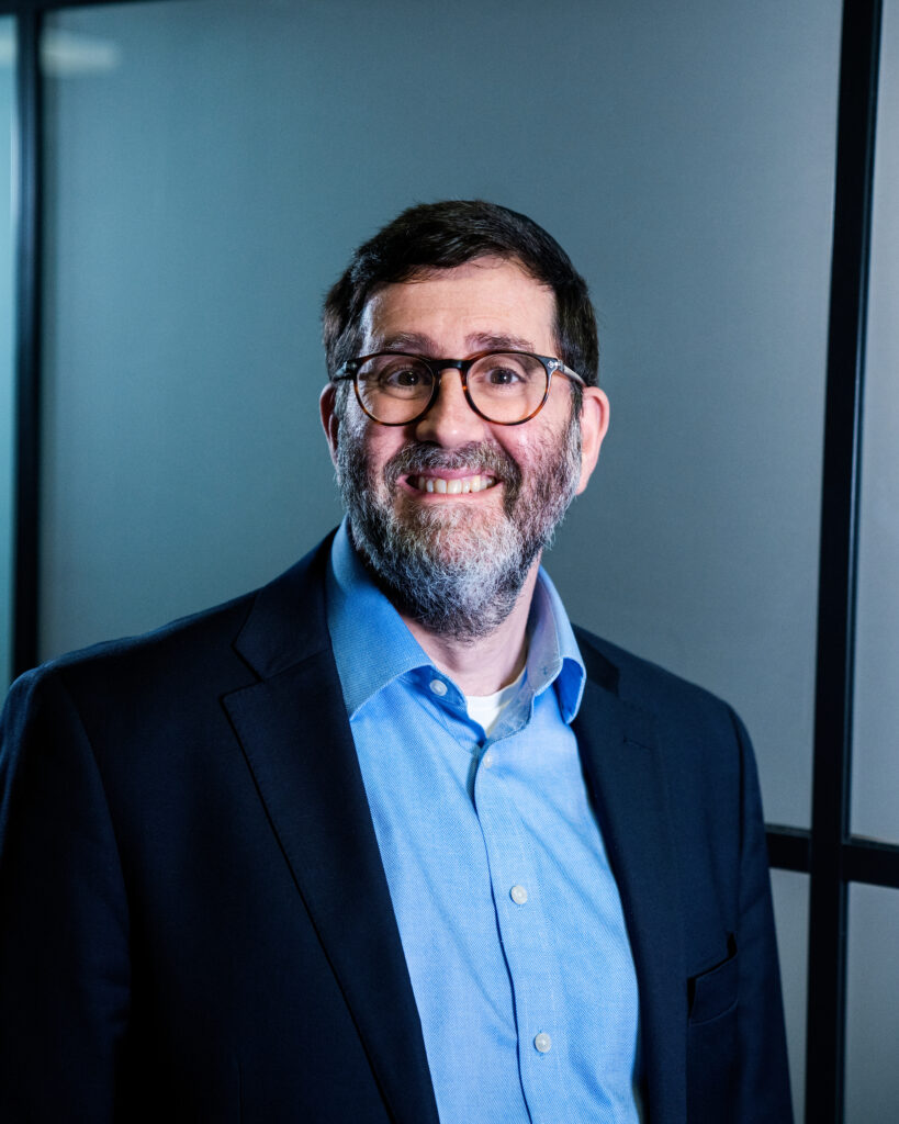 Portrait of Andrew Scher standing, professional headshot